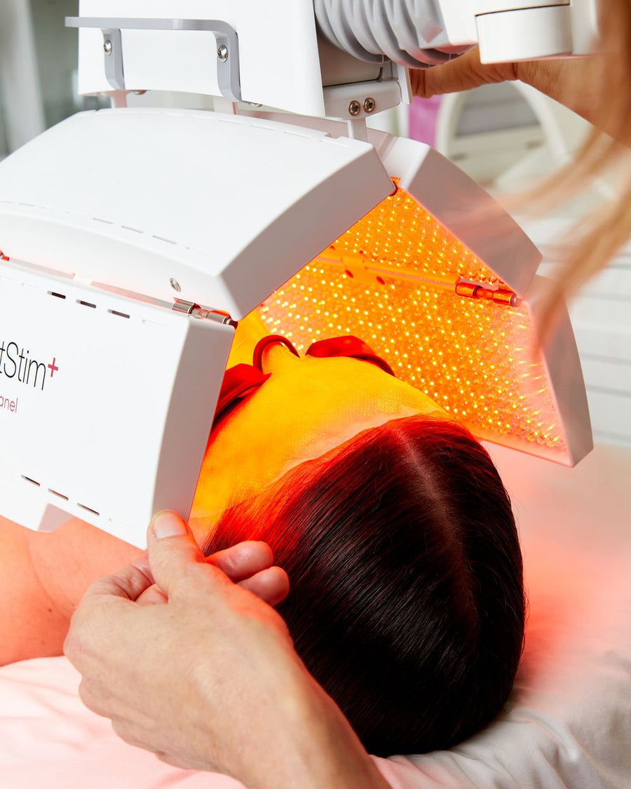 Esthetician holding a ProPanel over a client during a facial